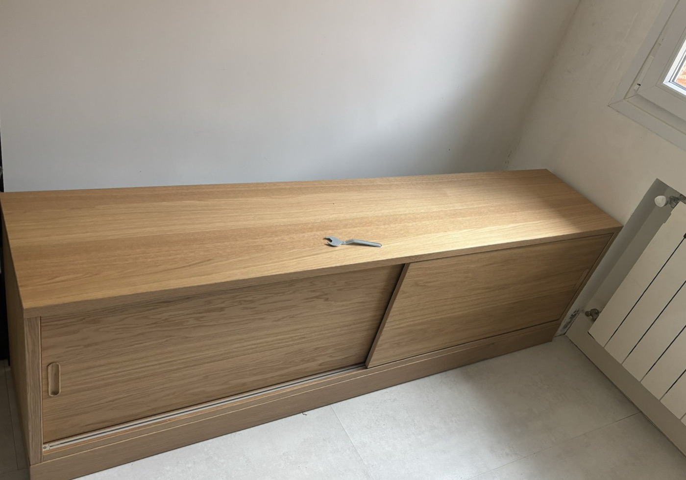 Aparador de madera con puertas correderas montado en salón